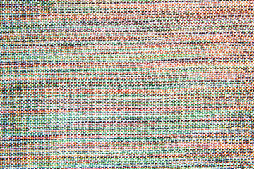 top view close up of woven fabric containing white, green, red, yellow and black; textile