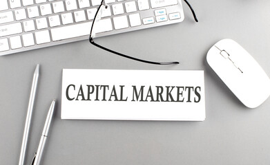 Poster - CAPITAL MARKETS text on paper with keyboard on grey background
