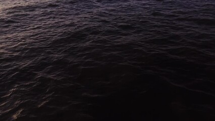 Wall Mural - Drone flies over dark sea water. Small waves, top view. Quadcopter video, no land, only water.