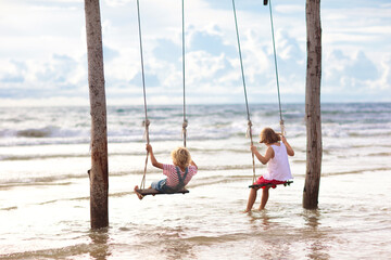 Child on swing. Kid swinging on beach.