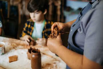 Wall Mural - Clay modeling lesson. Children's hands sculpts from clay crafts pottery school