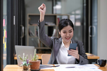 Asian business women are delighted and happy with their work on the phone and taking notes at the office.