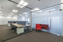 Modern Bright Office With Brown Carpet, Furniture And Glass Partitions.