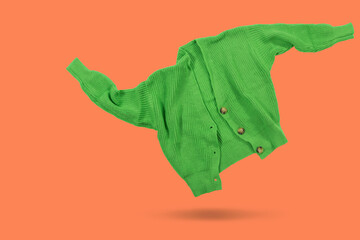 Wall Mural - Dancing green knitted sweater, buttons undone, levitates, concept, on a colored background