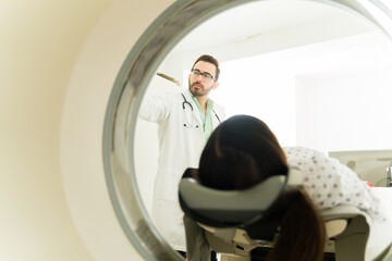 Wall Mural - Rear view of a patient getting a computed tomography with a doctor