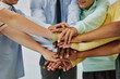 © Seventyfour - Close up of schoolchildren huddling in team exercise in classroom and stacking hands