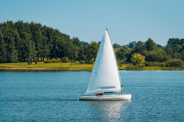 Sailing boat on a calm lake with reflection in the water