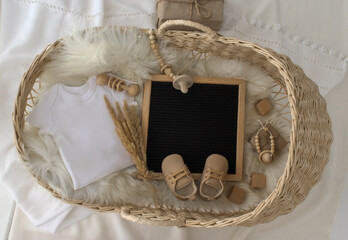 Mockup of white baby bodysuit shirt with basket, Letter Board Announcement .Pregnancy announcement background with blurred . Selective focus