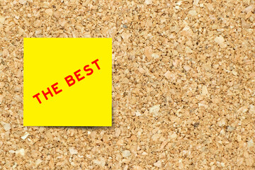 Sticker - Yellow note paper with word the best on cork board background with copy space