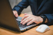 © Oatakoi - Closeup image of a business man's hands working and typing on laptop computer keyboard on office table.Business intelligence.