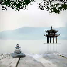 Balanced Zen Stack Of Stones On The Pier, Against The Background Of A Mirror Lake, Mountains And Gazebos For Meditation,