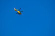 yellow helicopter in the blue sky