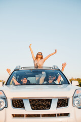 Wall Mural - car travel. fun happy people stick put of sun roof