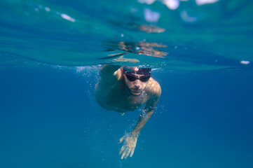 Sporty man swims fast in the sea