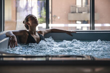 A Young Woman Is Relaxing In A Jacuzzi.