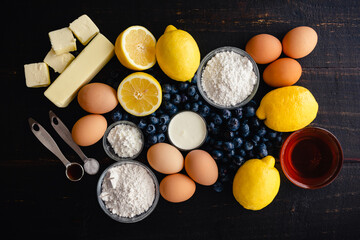 Wall Mural - Blueberry–Lemon Curd Tart Raw Ingredients on a Wood Table: Fresh blueberries, lemons, and other uncooked ingredients on a dark background