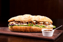 Large Shredded Beef Brisket Sandwich With Barbecue Sauce On Wooden Board Viewed From The Front