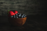 fresas y arandanos en bowl de madera