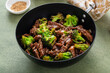 Beef and broccoli stir fry in a small wok