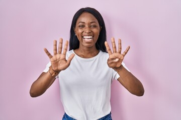 Sticker - African young woman wearing casual white t shirt showing and pointing up with fingers number nine while smiling confident and happy.