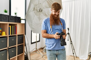 Sticker - Young redhead man photographer using professional camera at photograpy studio