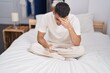 © Krakenimages.com - Young hispanic man using smartphone with worried expression at bedroom