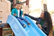 © Krakenimages.com - Mother and son playing on slide at park