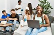 © Krakenimages.com - Group of young friends smiling happy sitting on the sofa. Woman using laptop at home.