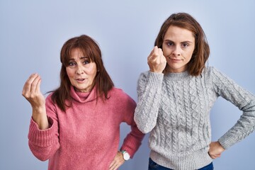 Sticker - Mother and daughter standing over blue background doing italian gesture with hand and fingers confident expression