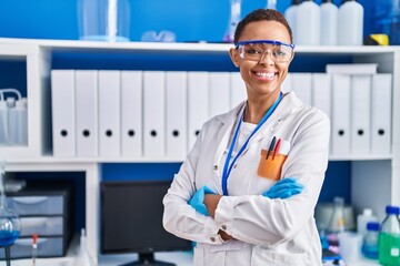 African american woman scientist smiling confident standing with arms crossed gesture at laboratory