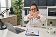 © Krakenimages.com - Young hispanic woman wearing doctor uniform and stethoscope rejection expression crossing arms and palms doing negative sign, angry face