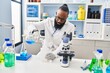 © Krakenimages.com - Young african american man wearing scientist uniform measuring liquid at laboratory