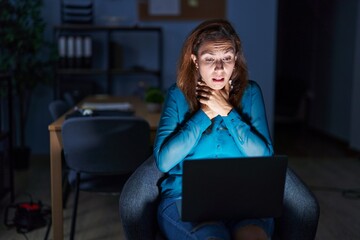 Wall Mural - Brunette woman working at the office at night shouting and suffocate because painful strangle. health problem. asphyxiate and suicide concept.