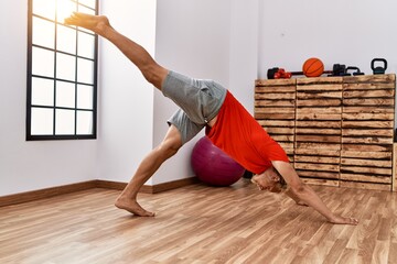 Poster - Young caucasian man stretching at sport center