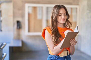 Canvas Print - Young woman student smiling confident writing on notebook at university