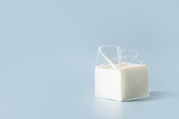 Fresh milk in glass jug on blue background. Healthy eating. Copy space. Close up.