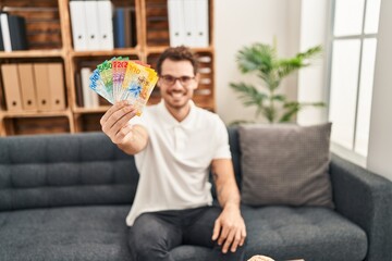 Sticker - Young hispanic man psychology holding swiss franc banknotes at psychology center