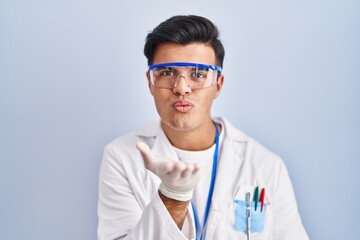 Poster - Hispanic man working as scientist looking at the camera blowing a kiss with hand on air being lovely and sexy. love expression.