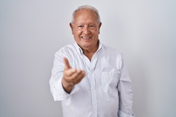 Poster - Senior man with grey hair standing over isolated background smiling cheerful offering palm hand giving assistance and acceptance.