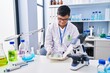 © Krakenimages.com - Down syndrome man wearing scientist uniform working at laboratory