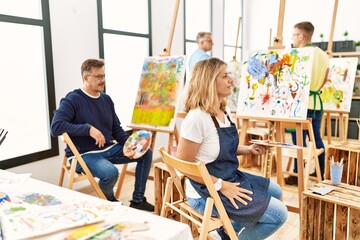 Poster - Group of middle age artist at art studio looking to side, relax profile pose with natural face and confident smile.