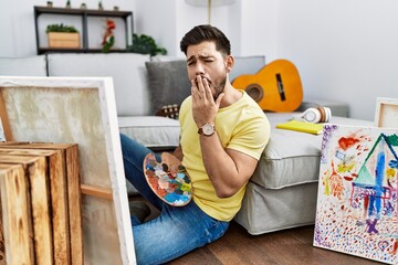 Poster - Young man with beard painting canvas at home bored yawning tired covering mouth with hand. restless and sleepiness.