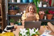 © Krakenimages.com - Young beautiful hispanic woman florist smiling confident using laptop at flower shop