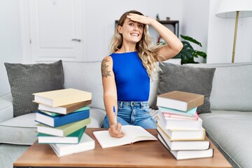 Sticker - Young beautiful woman writing on notebook around university books stressed and frustrated with hand on head, surprised and angry face