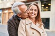© Krakenimages.com - Middle age man and woman couple hugging each other and kissing at street