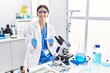 © Krakenimages.com - Young hispanic woman wearing scientist uniform using microscope at laboratory