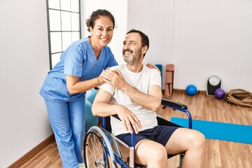 Canvas Print - Middle age man and woman smiling confident having physiotherapy session at physiotherapy clinic