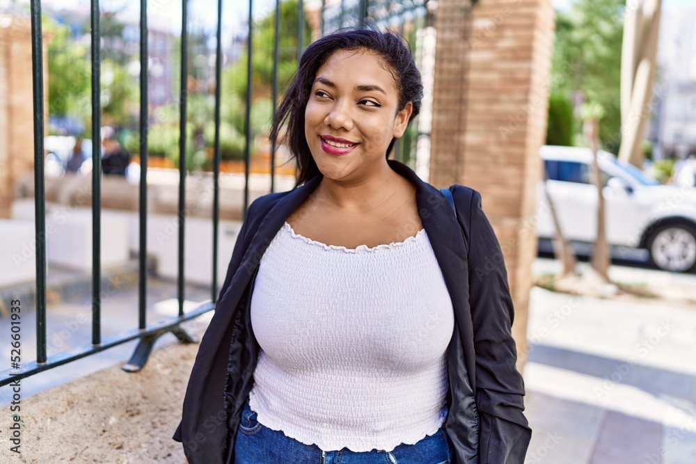 Beautiful hispanic woman smiling at the camera, walking outdoors on a ...