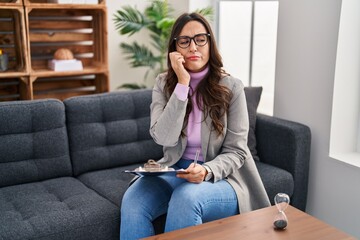 Sticker - Young brunette woman working at consultation office looking stressed and nervous with hands on mouth biting nails. anxiety problem.