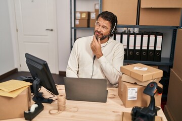 Poster - Handsome middle age man working at small business ecommerce wearing headset serious face thinking about question with hand on chin, thoughtful about confusing idea